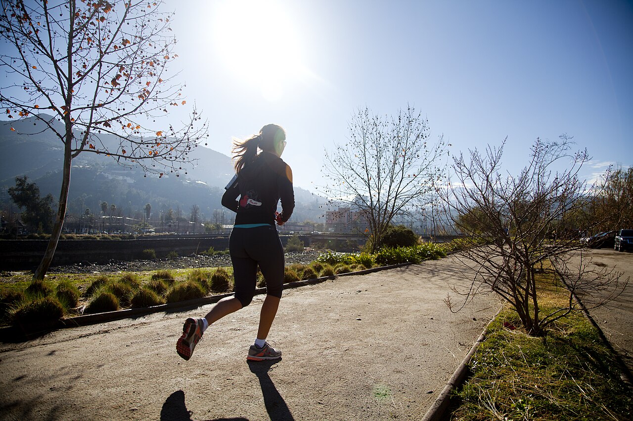 Una corredora avanza al aire libre con zapatillas de running